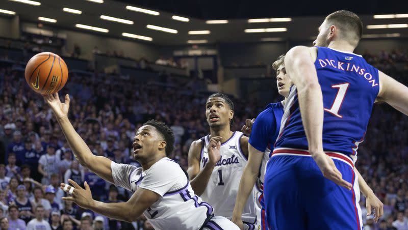 Kansas State’s Tylor Perry, left, throws up a reverse layup that helps the team defeat rival Kansas 75-70 in overtime. The upstart Wildcats will pay the Marriott Center a visit Saturday night for a clash against the Cougars.