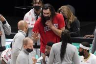 New Orleans Pelicans' Steven Adams, in red shirt, talks with members of the coaching staff during the first half of the team's NBA basketball game against the Dallas Mavericks in Dallas, Wednesday, May 12, 2021. Adams did not play in the game. (AP Photo/Tony Gutierrez)