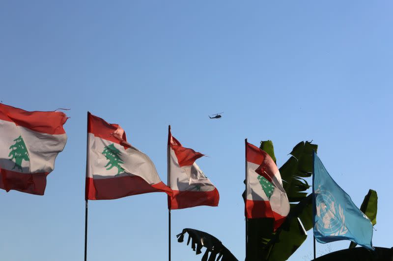 Lebanese and UN flags flutter as an aircraft flies in Naqoura ahead of talks between Israel and Lebanon on disputed waters, near the Lebanese-Israeli border