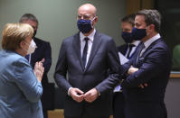 German Chancellor Angela Merkel, left, speaks with European Council President Charles Michel, center, and Luxembourg's Prime Minister Xavier Bettel during a round table meeting at an EU summit in Brussels, Thursday, Dec. 10, 2020. European Union leaders meet for a year-end summit that will address anything from climate, sanctions against Turkey to budget and virus recovery plans. Brexit will be discussed on the sidelines. (AP Photo/Olivier Matthys, Pool)