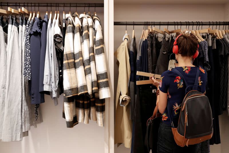 FILE PHOTO: A woman looks at clothes at the Rent The Runway store, an online subscription service for women to rent designer dress and accessory items, in New York City