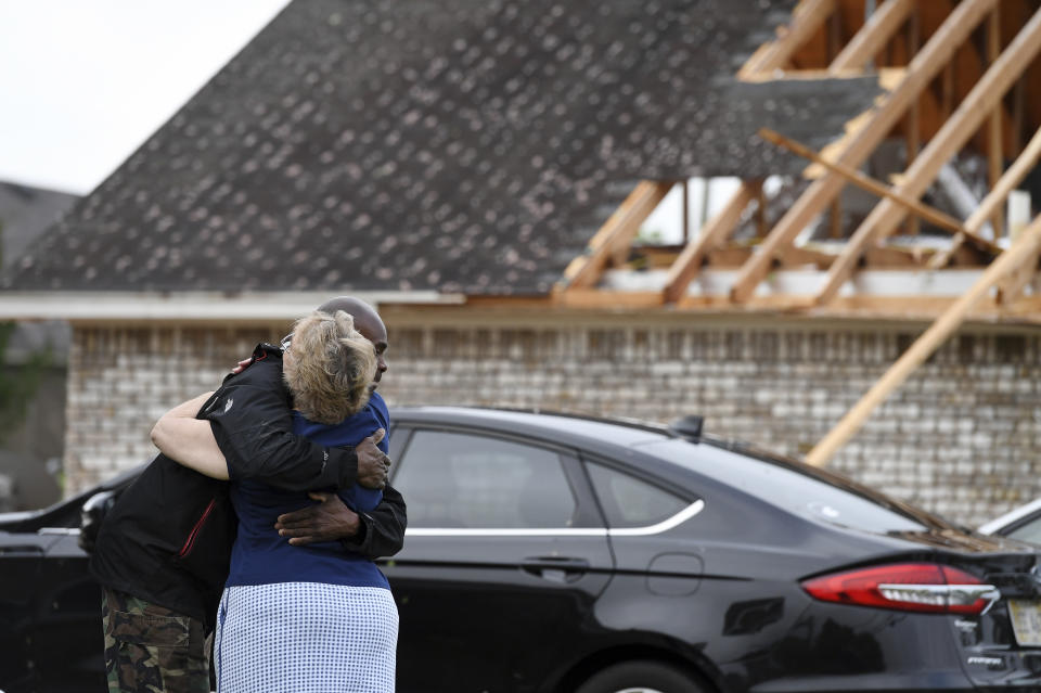 Neighbors Alfred Lee and Grace Bazzy hug in front of another neighbor's damaged home along Elvis Presley Drive in Tupelo, Miss., Monday, May 3, 2021. Multiple tornadoes were reported across Mississippi on Sunday, causing some damage but no immediate word of injuries. (AP Photo/Thomas Graning)