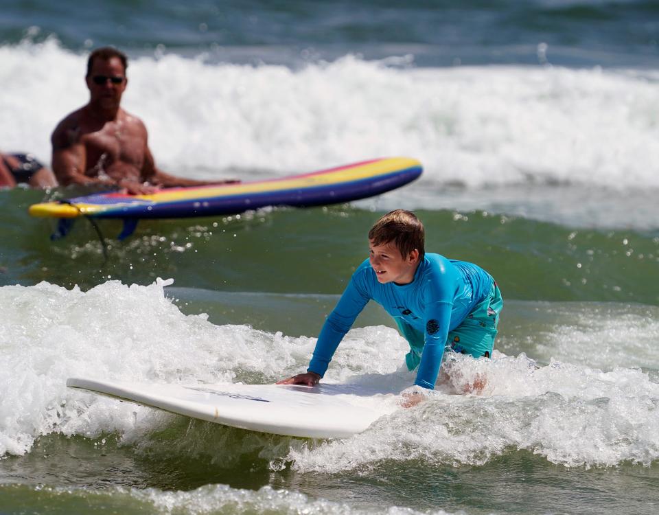 A young surfer attempts to ride a wave while getting surfing lessons in New Smyrna Beach, Monday, Sept. 7, 2020.