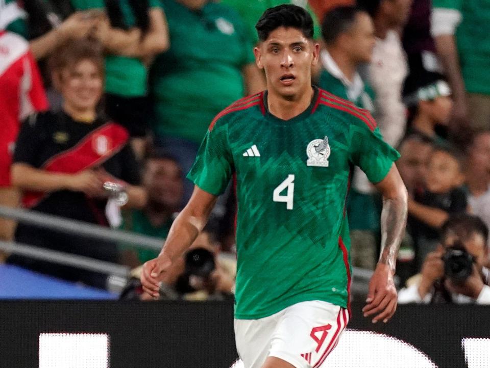 Mexico's Edson Alvarez dribbles the ball and looks on during a soccer match.