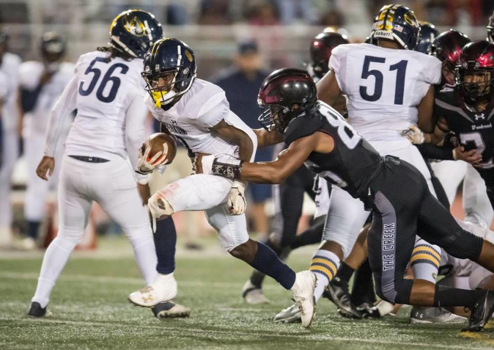 Inderkum Tigers running back Kyle Gurganious (8) runs up the middle as Woodcreek Timberwolves defensive lineman Issac Earls (85) hangs on for the tackle during on Friday in Roseville. Xavier Mascareñas/xmascarenas@sacbee.com
