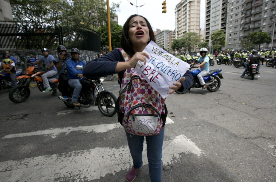 Una manifestante opositora al gobierno de Nicolás Maduro sostiene un cartel que dice: “Venezuela te quiero libre” mientras participa en la manifestación para pedir un referendum revocatorio del actual mandatario en Caracas este 18 de mayo de 2016. (AP Photo/Ariana Cubillos)