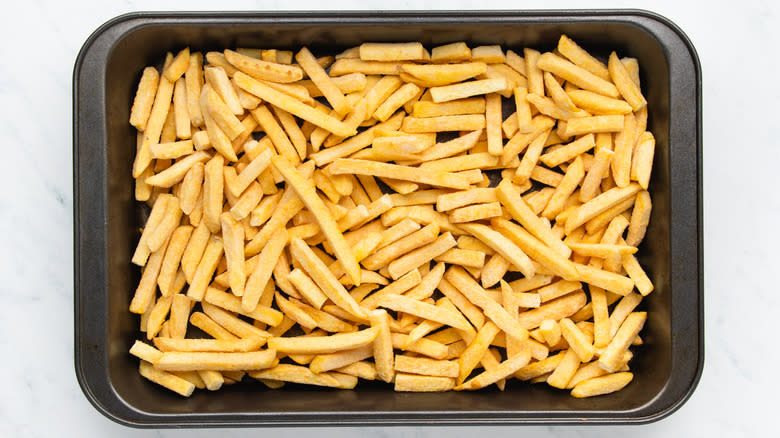 Frozen French fries on baking sheet