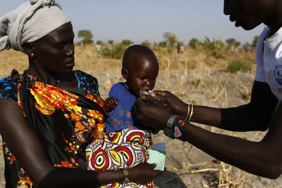 Angelina Nyanin, 25, holds her niece, Nyalel Gatcauk, 2, as a UNICEF nutrition worker feeds the baby Plumpy'Nut, a peanut-based paste for treatment of severe acute malnutrition in South Sudan on Feb. 26, 2017.