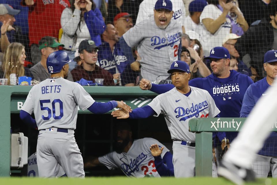 Los Angeles Dodgers' Mookie Betts (50) celebrates with manager Dave Roberts after scoring on a double by Will Smith against the Boston Red Sox during the sixth inning of a baseball game Friday, Aug. 25, 2023, in Boston. (AP Photo/Michael Dwyer)