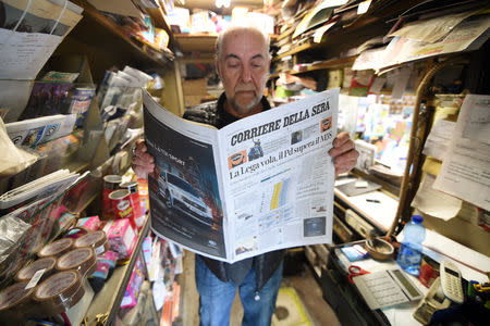 A man reads a newspaper with news of the rise of the far-right League party in Sunday's European parliamentary election in Milan, Italy May 27, 2019. REUTERS/Guglielmo Mangiapane