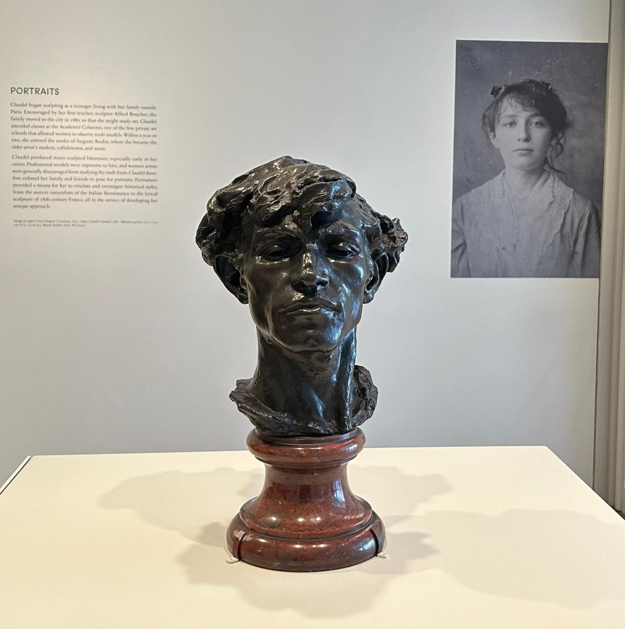 Photo of young Claudel behind her bust titled "Giganti" at the Art Institute of Chicago.