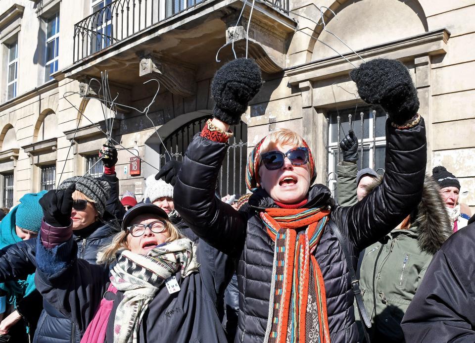 People hold up&nbsp;wire hangers as they demonstrate in front of the seat of the Warsaw archdiocese on March 18. (Photo: JANEK SKARZYNSKI/AFP/Getty Images)