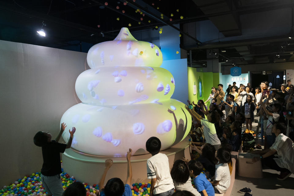 In this Monday, July 1, 2019, photo, a group of children try to catch small toy poops gushing from a giant poop-shaped inflatable at the Unko Museum in Yokohama, south of Tokyo. In a country known for its cult of cute, even poop is not an exception. A pop-up exhibition at the Unko Museum in the port city of Yokohama is all about unko, a Japanese word for poop. The poop installations there get their cutest makeovers. They come in the shape of soft cream, or cupcake toppings. (AP Photo/Jae C. Hong)