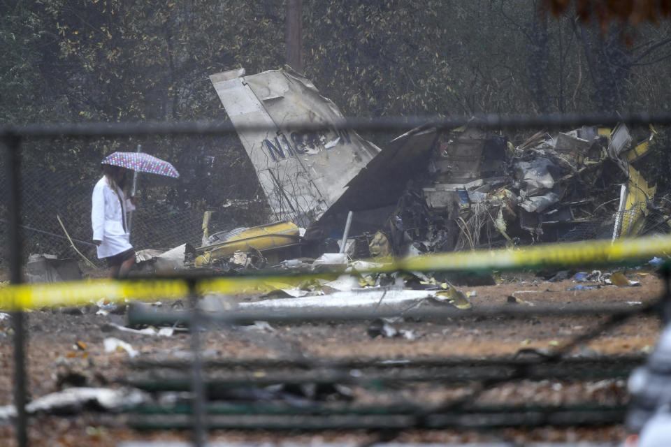 A person investigates the scene of a small plane crash in a city park which killed all on board, Thursday, Dec. 20, 2018, in northwest Atlanta. (AP Photo/John Amis)