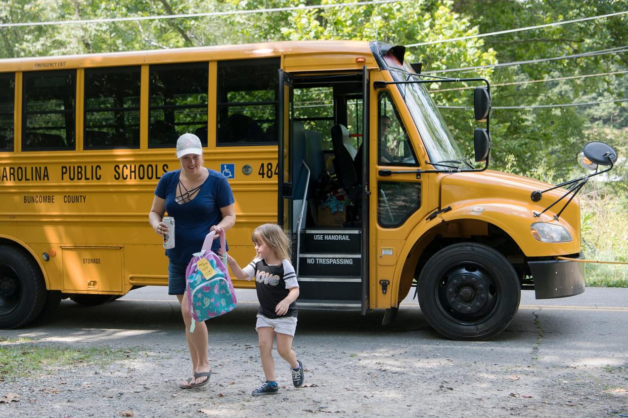 Leslie Hussueng helps her daughter Lexie, 5, off of the school bus as she arrives home from Black Mountain Primary School on Aug. 21, 2019. Hussueng drives her daughter to school in the mornings because the kindergartener would be picked up before 6 a.m. for an 8 a.m. school start time.