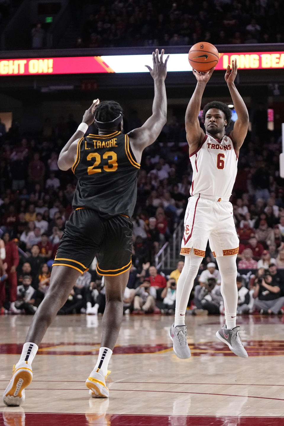 Southern California guard Bronny James, right, shoots as Long Beach State forward Lassina Traore defends during the first half of an NCAA college basketball game Sunday, Dec. 10, 2023, in Los Angeles. (AP Photo/Mark J. Terrill)