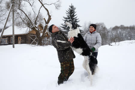 Dmitry Shamovich and his wife Anastasia Kuzmenkova play with the dog Amur at their homestead Zaimka Leshego in the village of Sosnovy Bor, Belarus, February 7, 2018. "Four years ago I was here, at the homestead for the first time - we arrived with other birdwatchers to build artificial nests for owls. And I met Dmitry, the owner of homestead, for the first time, here. Later we met again, when I arrived to be a volunteer in a project related to capercaillie. After that we made more projects together and one day I understood I fell in love with him. It was mutual," said Anastasia. REUTERS/Vasily Fedosenko