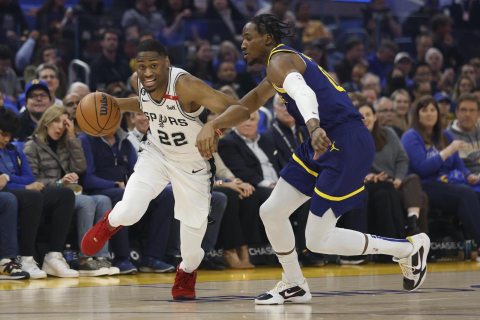 San Antonio Spurs guard Malaki Branham, left, drives to the basket against Golden State Warriors forward Jonathan Kuminga, right, during the first half of an NBA basketball game in San Francisco, Friday, March 31, 2023. (AP Photo/Jed Jacobsohn)