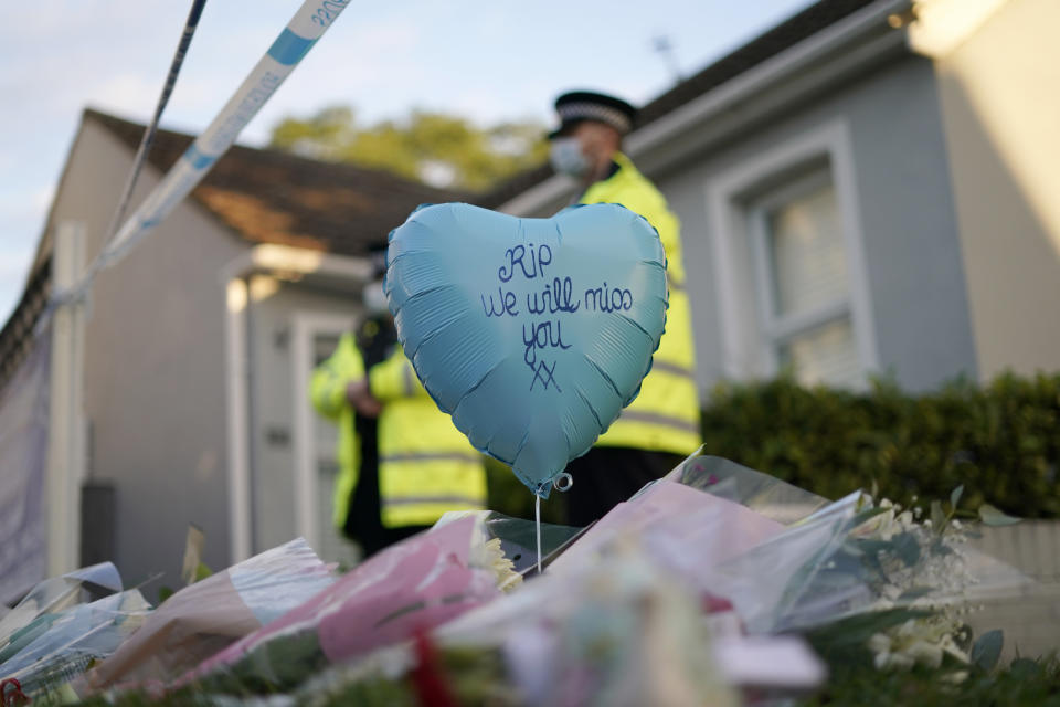 A balloon and floral tributes are placed on the road leading to the Belfairs Methodist Church in Eastwood Road North, in Leigh-on-Sea, Essex, England, Saturday, Oct. 16, 2021. David Amess, a long-serving member of Parliament was stabbed to death during a meeting with constituents at a church in Leigh-on-Sea on Friday, in what police said was a terrorist incident. A 25-year-old man was arrested in connection with the attack, which united Britain's fractious politicians in shock and sorrow. (AP Photo/Alberto Pezzali)