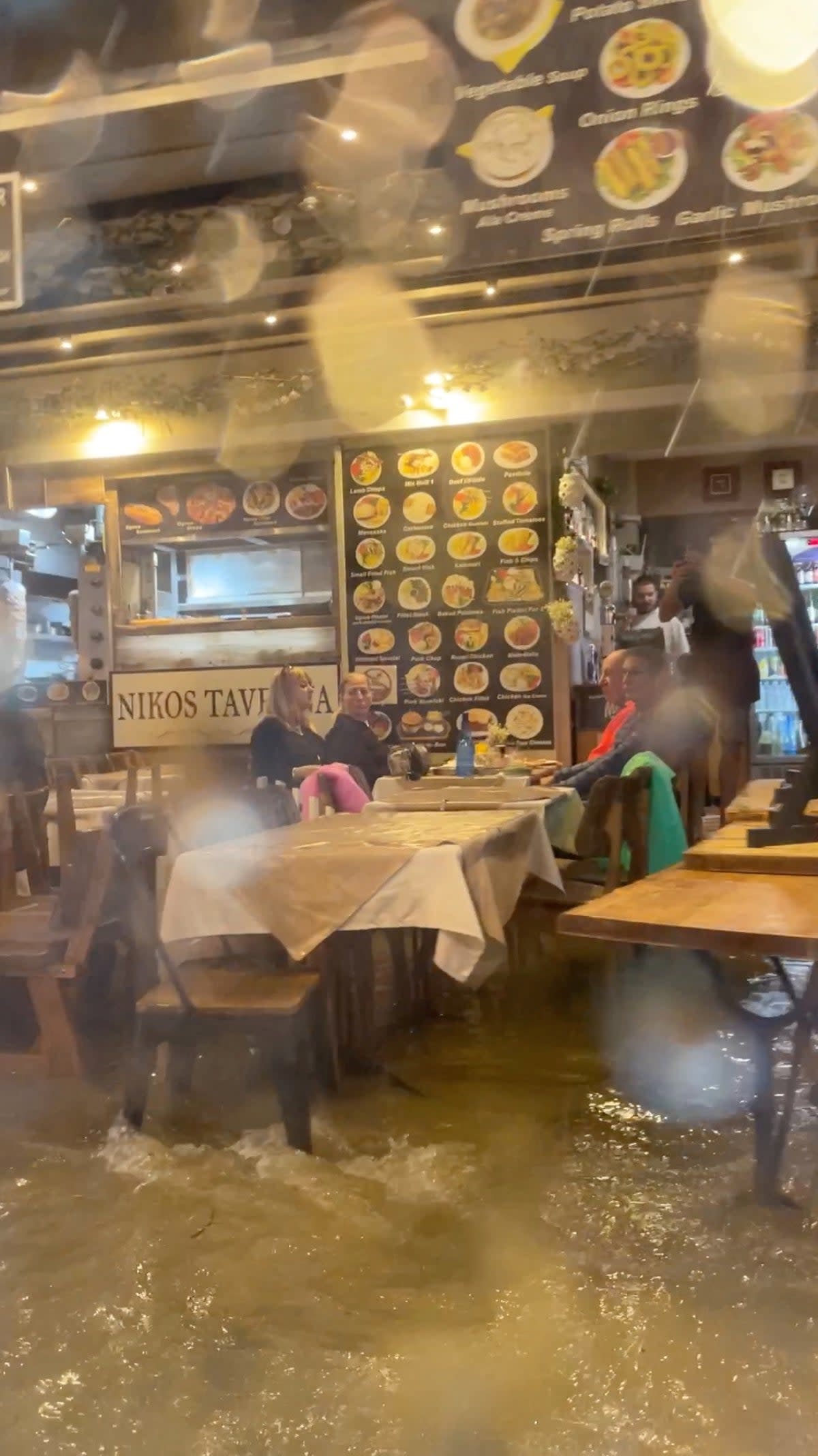 A flooded restaurant is seen from a car in Skiathos (ANDREW CALLAGHAN via REUTERS)