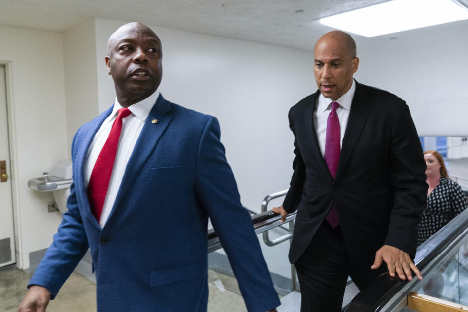 FILE - Sen. Tim Scott, R-S.C., left, and Sen. Cory Booker, D-N.J. talk as they walk from the Senate subway on Capitol Hill in Washington, July 30, 2021. The U.S. Senate’s only Black Republican is putting forth what he characterizes as a positive response to partisan rhetoric on race that he’s best-positioned to rebut. Tim Scott of South Carolina tells The Associated Press that he hopes a video series on issues he sees as pertinent to the Black community will help refocus a fraught national conversation on race. Scott has timed the release in conjunction with Martin Luther King Jr. Day. (AP Photo/Manuel Balce Ceneta, File)