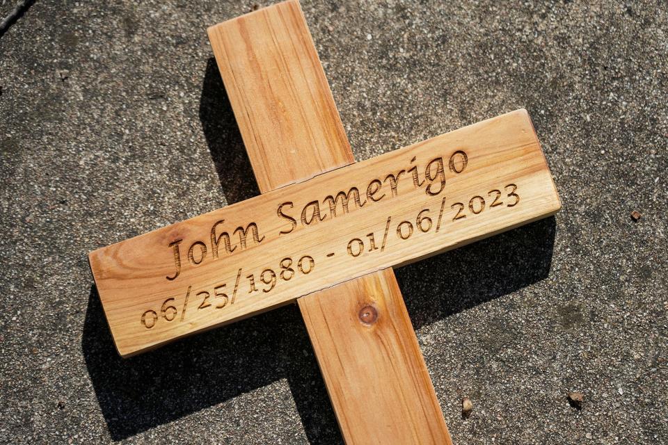 Lynn Samerigo's friends gathered to commemorate the one-year anniversary of the death of her husband, John, by placing a cross outside the house.