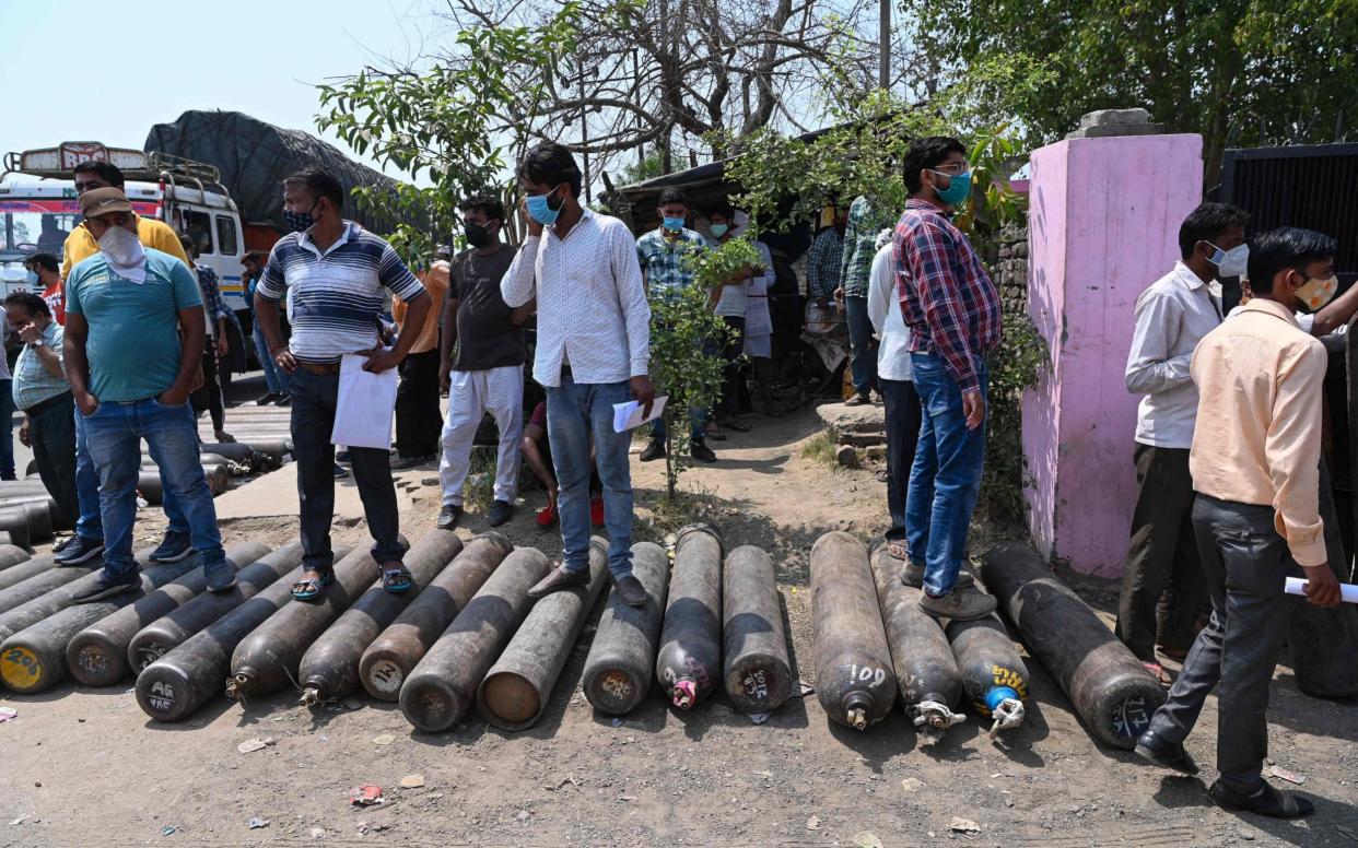 People wait outside to refill their cylinders with oxygen for Covid-19 coronavirus patients, at an oxygen refilling centre in Moradabad  - Prakash Singh/AFP