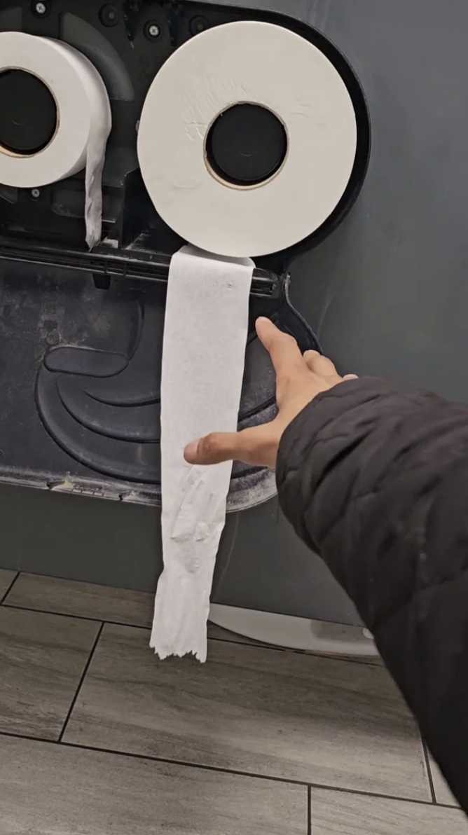 Person trying to reach toilet paper that is out of reach