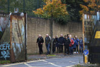 In this image taken on Tuesday, Oct. 15, 2019 former IRA member Jack Duffin, left, from Belfast political tours takes tourists through the peace wall to a Loyalist area in west Belfast, Northern Ireland. Fears about a return to the violence that killed more than 3,500 people over three decades have made Northern Ireland the biggest hurdle for U.K. and EU officials who are trying to hammer out a Brexit divorce deal. (AP Photo/Peter Morrison)