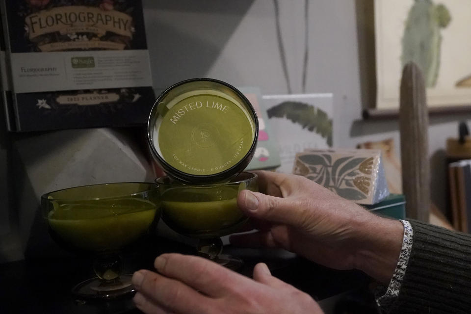 Nathan Waldon, owner of Nathan & Co., holds a Paddywax candle while interviewed at his store in Oakland, Calif., Monday, Dec. 12, 2022. Small retailers say this year looks much different than the last "normal" pre-pandemic holiday shopping season of 2019. They're facing decades-high inflation forcing them to raise prices and making shoppers rein in the freewheeling spending seen in 2021 when they were flush with pandemic aid and eager to spend. (AP Photo/Jeff Chiu)