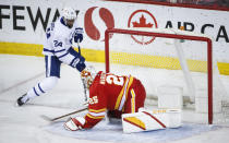 Toronto Maple Leafs' Wayne Simmonds, left, scores on Calgary Flames goalie Jacob Markstrom during the first period of an NHL hockey game, Tuesday, Jan. 26, 2021 in Calgary, Alberta. (Jeff McIntosh/The Canadian Press via AP)