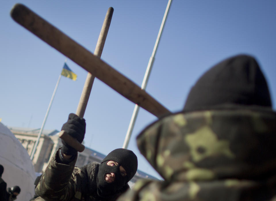 Members of the radical group Pravy Sektor (Right Sector) practice street fighting in central Kiev, Ukraine, Monday, Feb. 3, 2014. Ukraine's president will return Monday from a short sick leave that had sparked a guessing game he was taking himself out of action in preparation to step down or for a crackdown on widespread anti-government protests. (AP Photo/Darko Bandic)