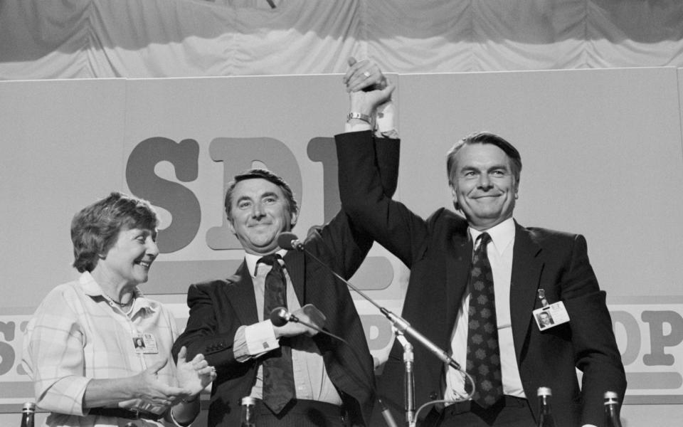 Social Democratic Party President Shirley Williams applauding Liberal leader David Steel, centre, who has joined hands with SDP leader Dr David Owen after Mr Steel's speech to the SDP conference in Torquay, 1985 - PA