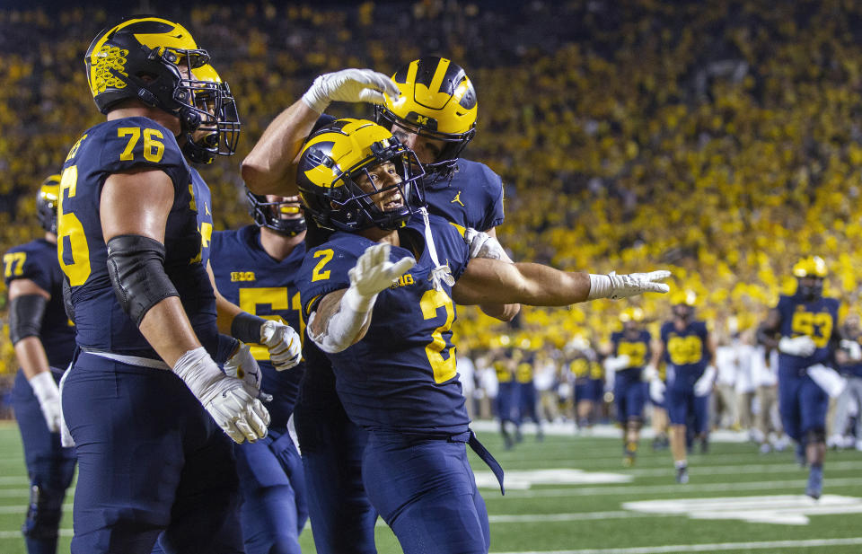 Michigan running back Blake Corum (2) celebrates a touchdown with teammates during the fourth quarter of an NCAA college football game against Washington in Ann Arbor, Mich., Saturday, Sept. 11, 2021. (AP Photo/Tony Ding)