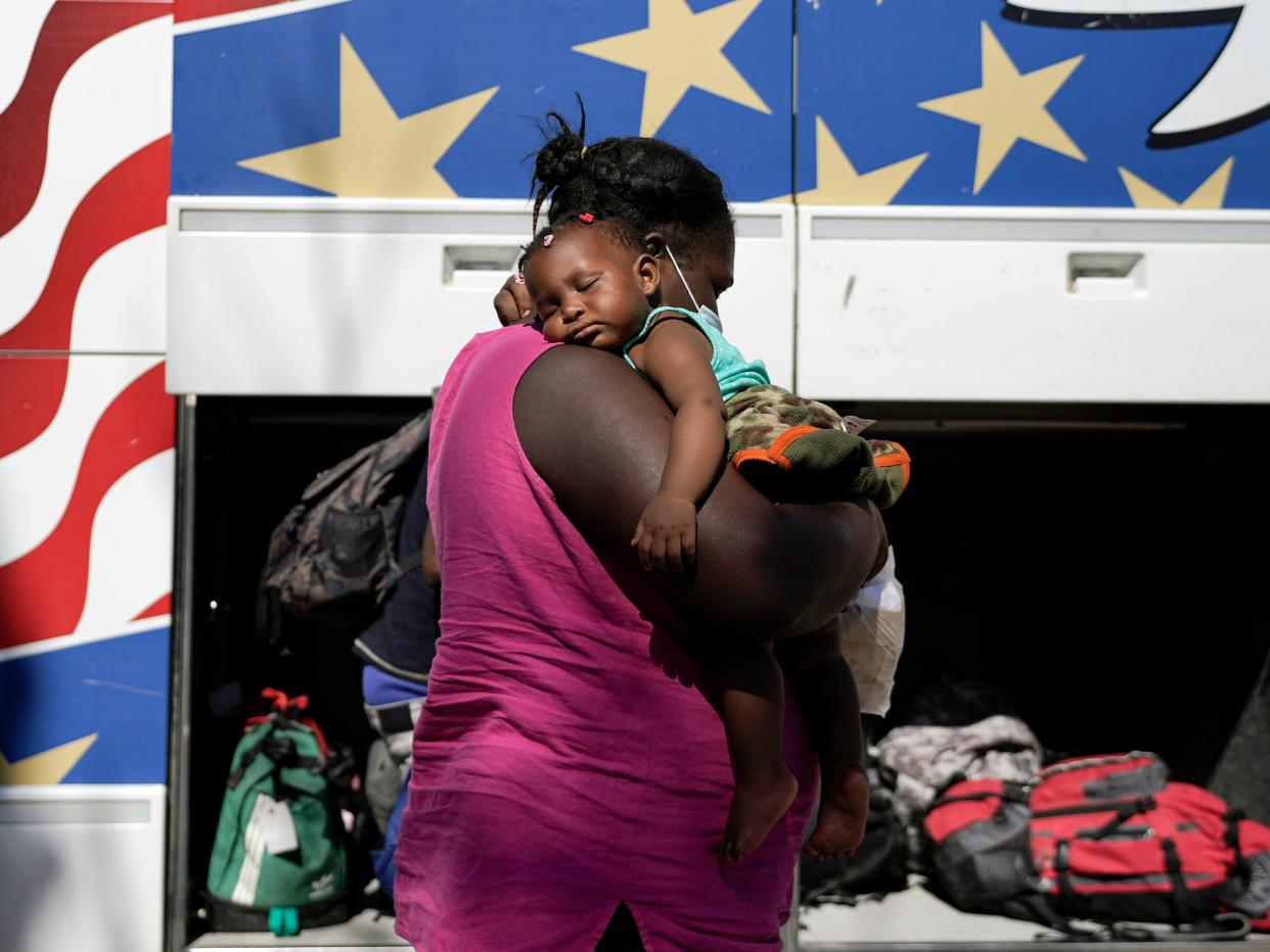 A mother and her young child preparing to board a bus at the US-Mexico border (AP)