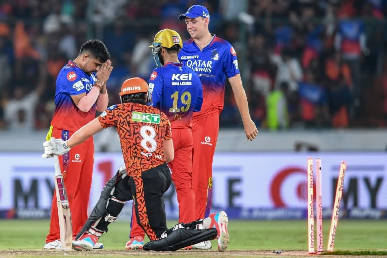 Royal Challengers Bengaluru's Karn Sharma (L) celebrates with teammates after taking the wicket of Sunrisers Hyderabad's Nitish Kumar Reddy during their Indian Premier League Twenty20 cricket match in Hyderabad on April 25, 2024 (Noah SEELAM)