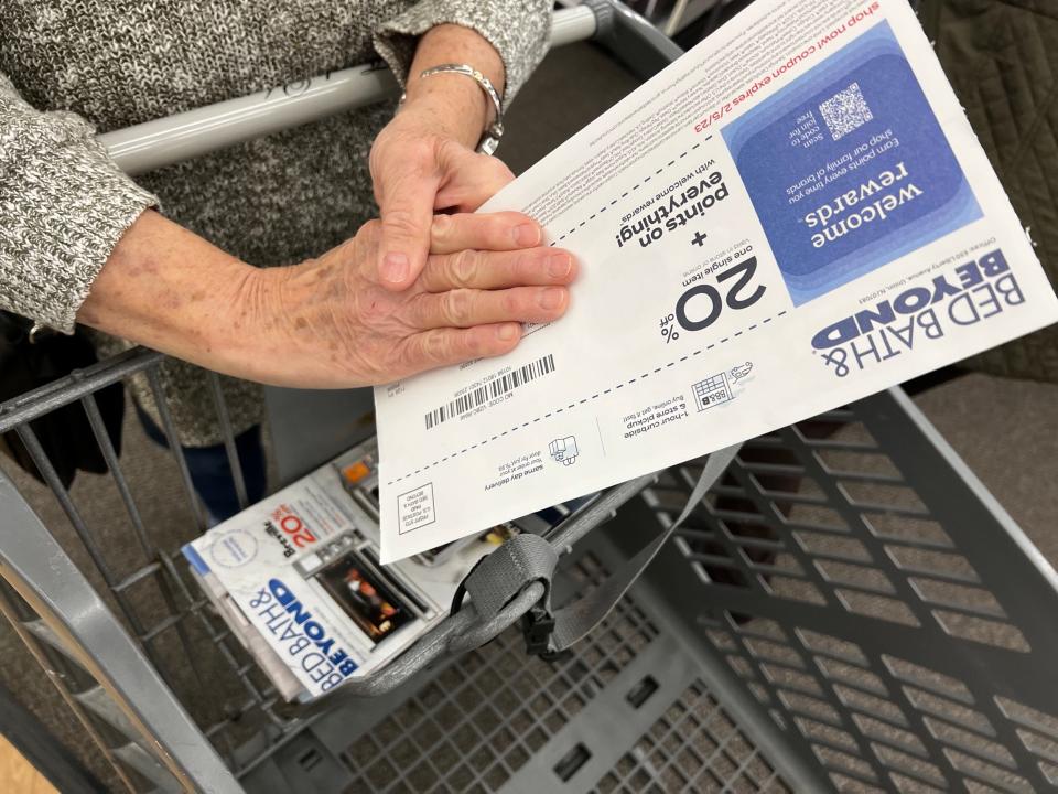 A customer shows her coupons at a Bed Bath & Beyond store