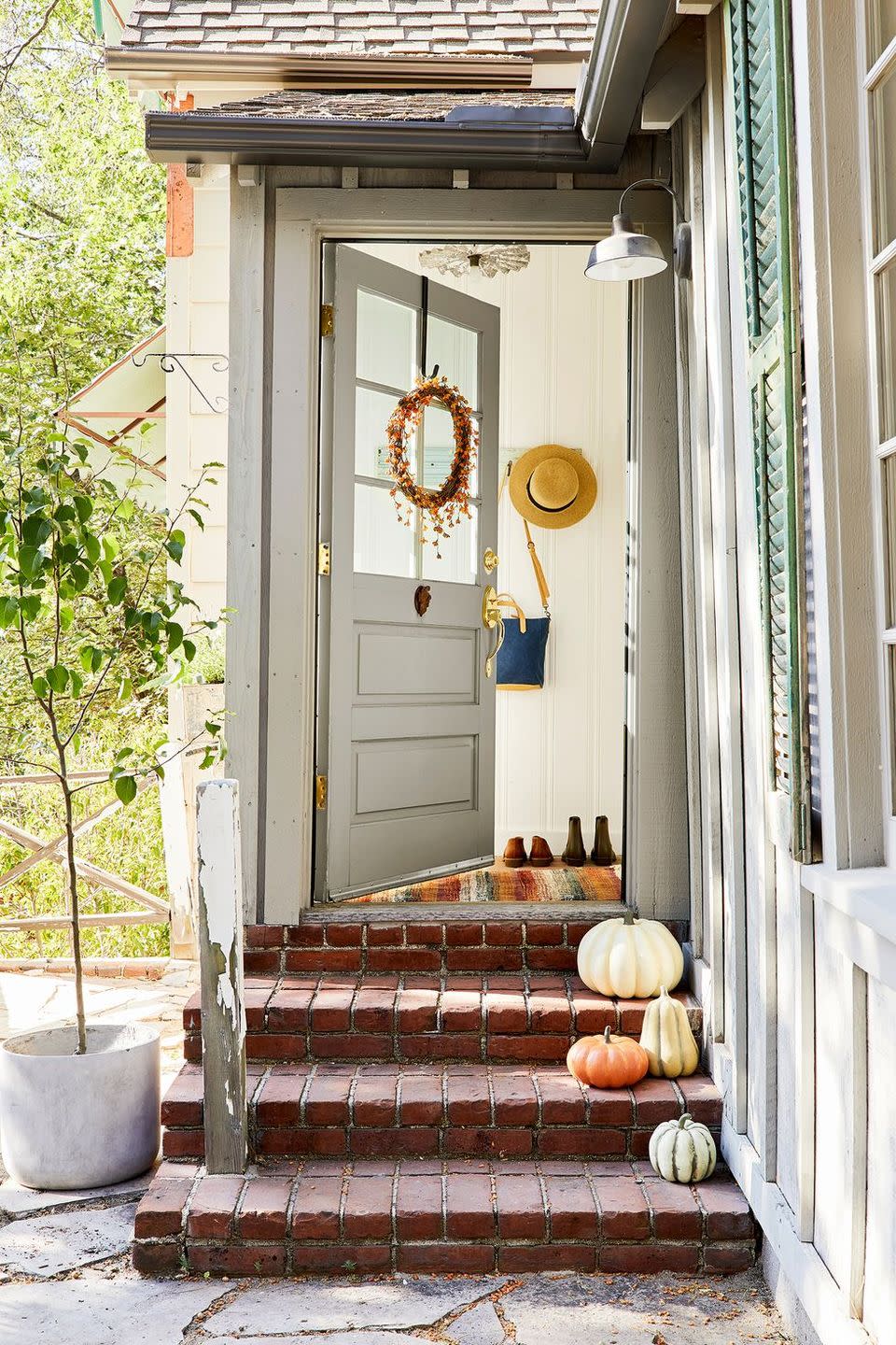 <p>Opt for a fall-friendly runner or welcome mat by the door instead of the one you used all summer. And bonus points if you line the front steps with pumpkins that reflect the orange beaded wreath on the door. </p>