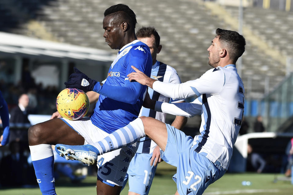 Lazio's Danilo Cataldi and Brescia's Mario Balotelli, left, vie for the ball during the Italian Series A soccer match between Brescia and Lazio at the Mario Rigamonti stadium in Brescia, Italy, Sunday, Jan. 5, 2020. (Gianluca Checchi/LaPresse via AP)