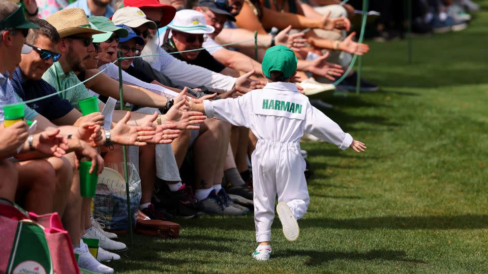 Walter Harman, son of defending Open champion Brian Harman, high fives crowds during the contest. - Mike Blake/Reuters