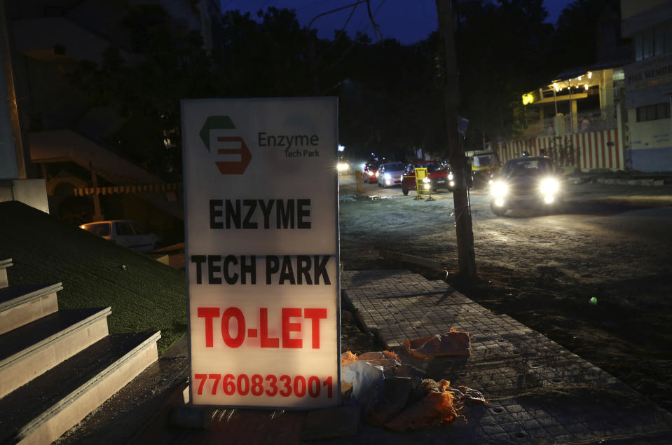 Cars drive past a to-let sign displayed by a company offering office spaces in Bengaluru, India, Tuesday, Oct. 13, 2020. Thousands of students and professionals who worked for IT companies and lived in the area have moved back to their native places to work remotely. Even as much of the Indian economy has reopened, Bengaluru’s professional workforce is returning to work at a much slower pace than those in most other major cities, raising the risk that the city faces a more protracted recovery. (AP Photo/Aijaz Rahi)