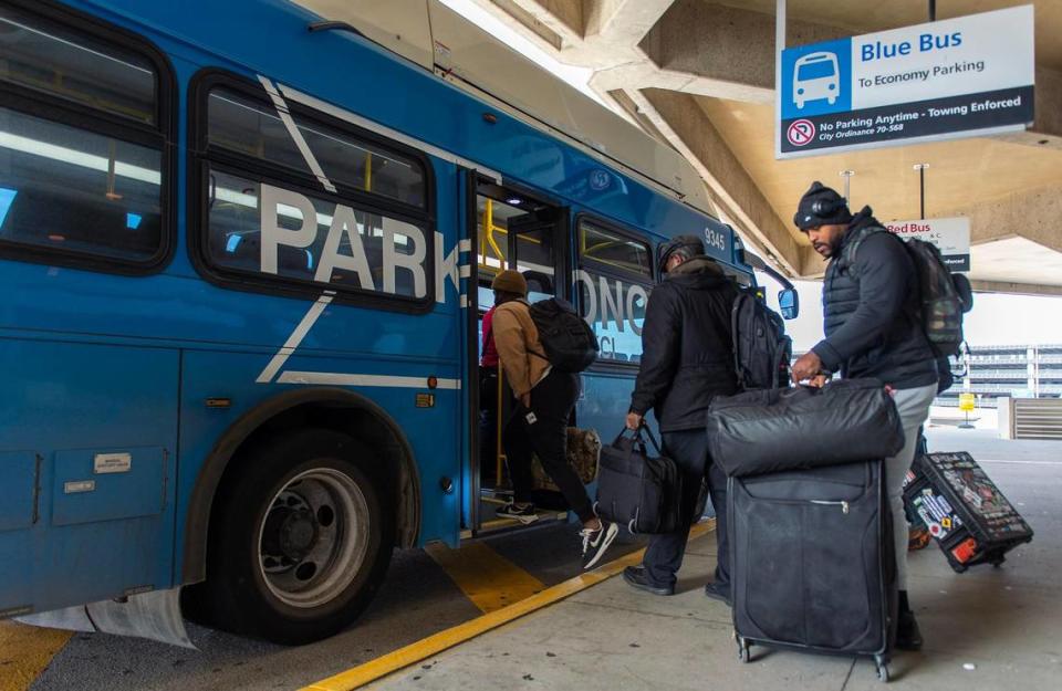 Travelers board the Blue Bus, an economy parking lot shuttle, outside of Kansas City International Airport’s Terminal B on Thursday, Dec. 1, 2022, in Kansas City.