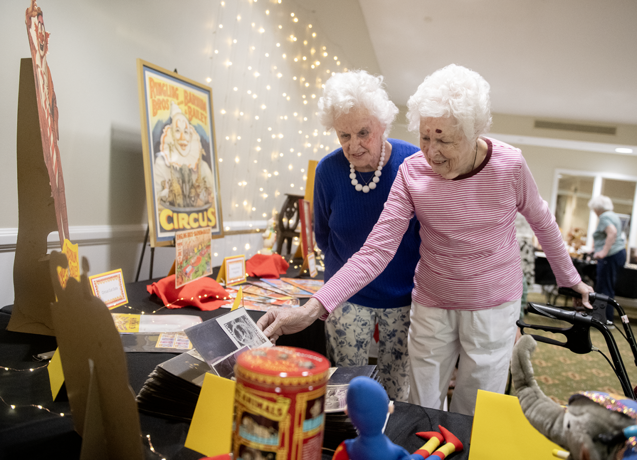 Betty Osmer and Marilyn Sullivan, both residents at Independence Village of Aurora, take in the memorabilia at Ed’s Dream Big circus showcase at the assisted living facility Thursday.