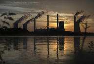 FILE - In this Saturday, June, 3, 2017 file photo, the coal-fired Plant Scherer, one of the nation's top carbon dioxide emitters, stands in the distance in Juliette, Ga.. World leaders breathed an audible sigh of relief that the United States under President Joe Biden is rejoining the global effort to curb climate change, a cause that his predecessor had shunned. British Prime Minister Boris Johnson and French President Emmanuel Macron were among those welcoming Biden’s decision on Wednesday, Jan. 20, 2021 to rejoin the the Paris climate accord. (AP Photo/Branden Camp, file)