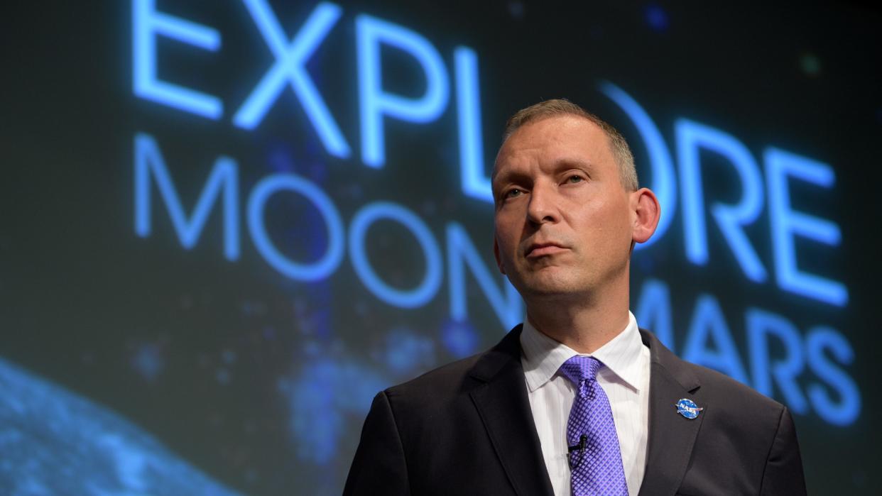  nasa associate administrator thomas zurbuchen in front of the words explore moon mars 