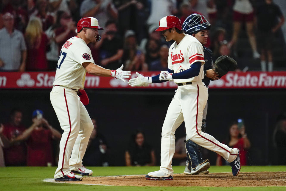 Los Angeles Angels designated hitter Shohei Ohtani (17) celebrates with Mike Trout, left, after hitting a home run during the sixth inning of a baseball game against the New York Yankees in Anaheim, Calif., Wednesday, Aug. 31, 2022. David Fletcher and Trout also scored. (AP Photo/Ashley Landis)