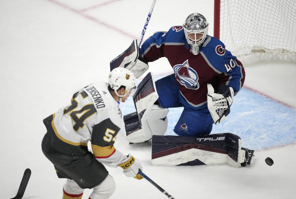 Colorado Avalanche goaltender Alexandar Georgiev, back, deflects a shot by Vegas Golden Knights left wing Grigori Denisenko during the third period of an NHL hockey game Wednesday, Jan. 10, 2024, in Denver. (AP Photo/David Zalubowski)