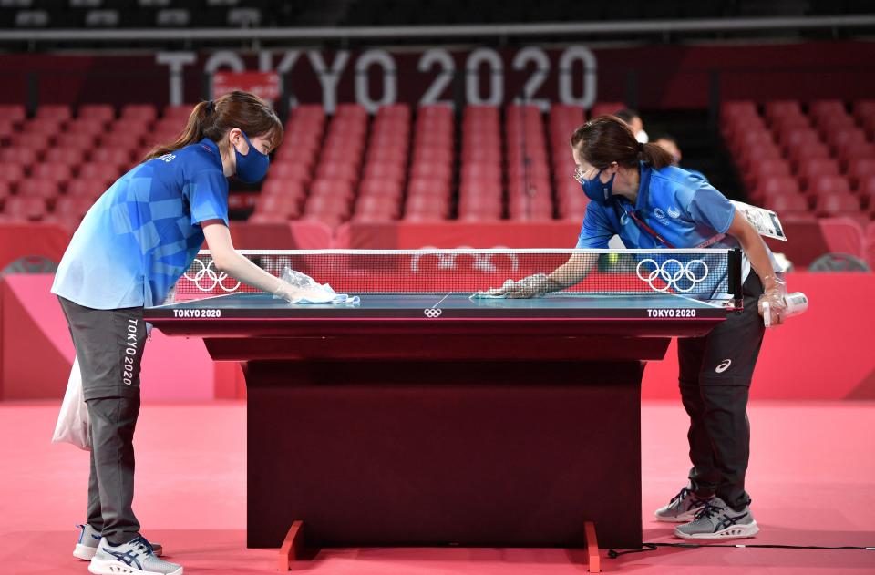 <p>Tokyo 2020 volunteers sanitise a table during a table tennis training session at the Tokyo Metropolitan Gymnasium, in Tokyo, on July 21, 2021, ahead of the Tokyo 2020 Olympic Games. (Photo by Jung Yeon-je / AFP) </p> 