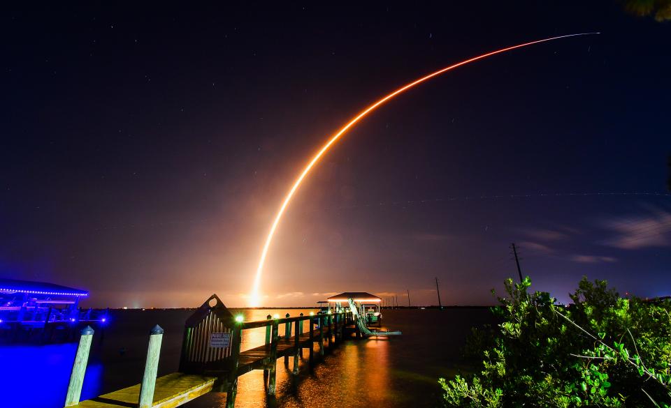 A SpaceX Falcon 9 rocket carrying Starlink satellites launches Thursday night, as seen across the Indian River Lagoon from the Cocoa shoreline.