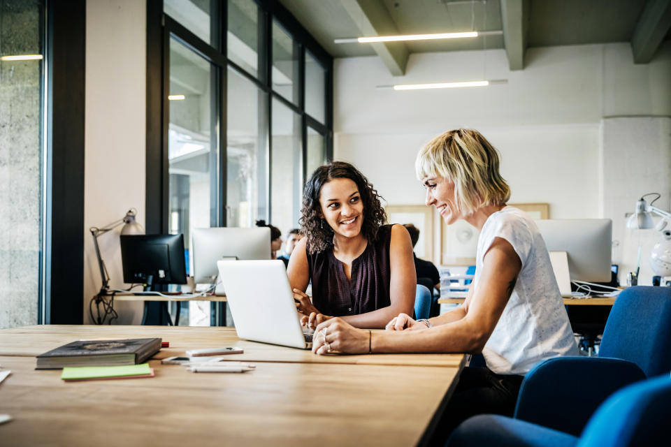 Two casual dressed start up businesswomen talking in a meeting with laptop